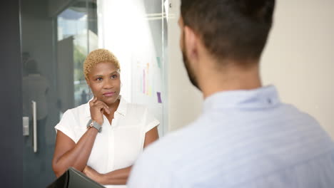 collaborating on project details, multiracial colleagues discussing in modern office environment
