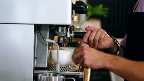 camarero haciendo una taza de café