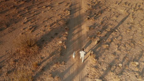 Man-walking-pit-bull-off-leash-through-the-mojave-desert