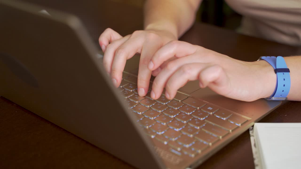 las manos femeninas están escribiendo texto en el teclado de la computadora portátil. los dedos presionan rápidamente las teclas del teclado. hay un cuaderno al lado. computadora personal, trabajo remoto en casa, negocios, estudio, mensajería, chat