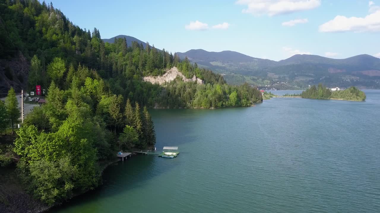 panorámica aérea del lago-embalse en el valle con montañas al fondo.