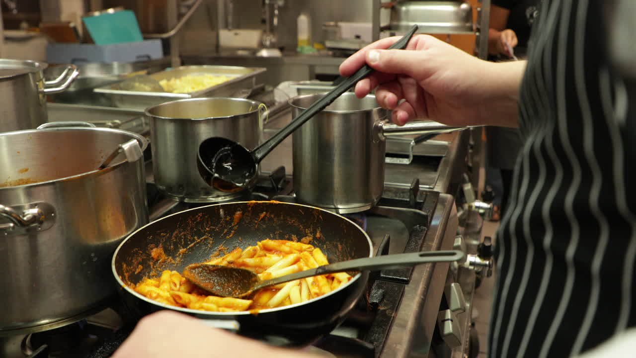 chef adicionando uma concha de caldo de macarrão penne em uma panela - close-up, câmera lenta