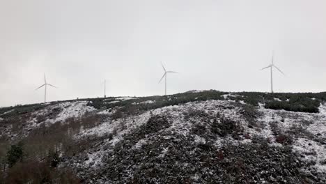 Verschneiter-Hügel-Mit-3-Modernen-Windmühlen-An-Einem-Bewölkten-Tag