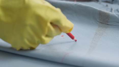 trabajador marcando pieles de animales con un bolígrafo de cera en una fábrica de textiles en pakistán