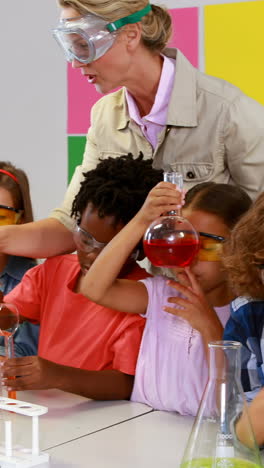 maestro de escuela ayudando a los niños de la escuela en un experimento químico en el laboratorio