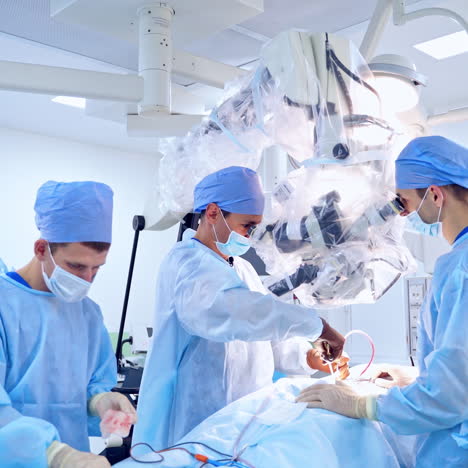 operation through microscope. group of surgeons doing operation to a patient. doctors use modern equipment in the operating room.