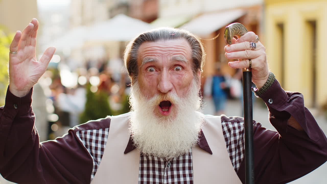 카메라를 쳐다보는 시니어 남자가 놀라서 갑작스러운 승리로 충격을 받았습니다. 좋은 승리 소식, 와우 시내 거리에서