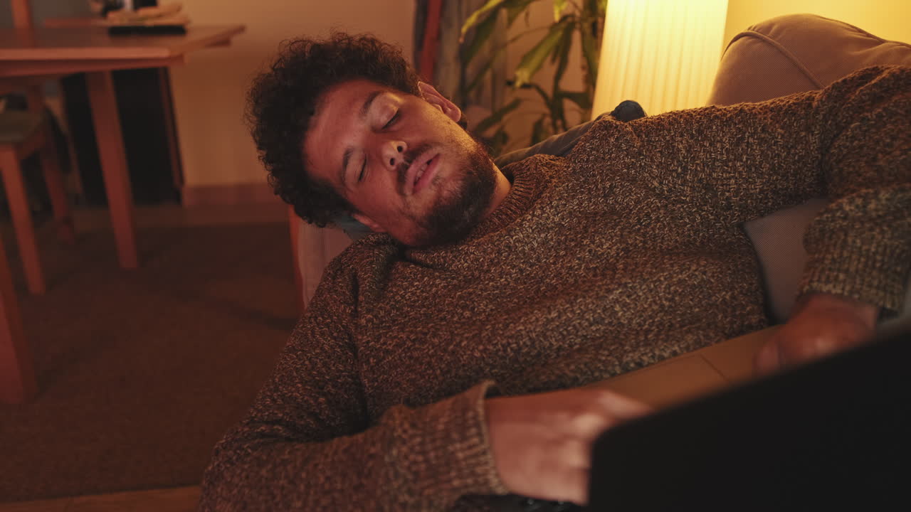 Man sleeping on couch with laptop
