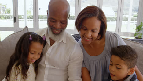 Vista-Frontal-De-Una-Familia-Negra-Sentada-En-El-Sofá-En-Una-Casa-Cómoda-4k