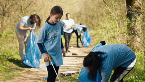 Mamá-Y-Niño-Recogiendo-Basura-Del-área-Forestal-Usando-Una-Herramienta-De-Garra-Larga