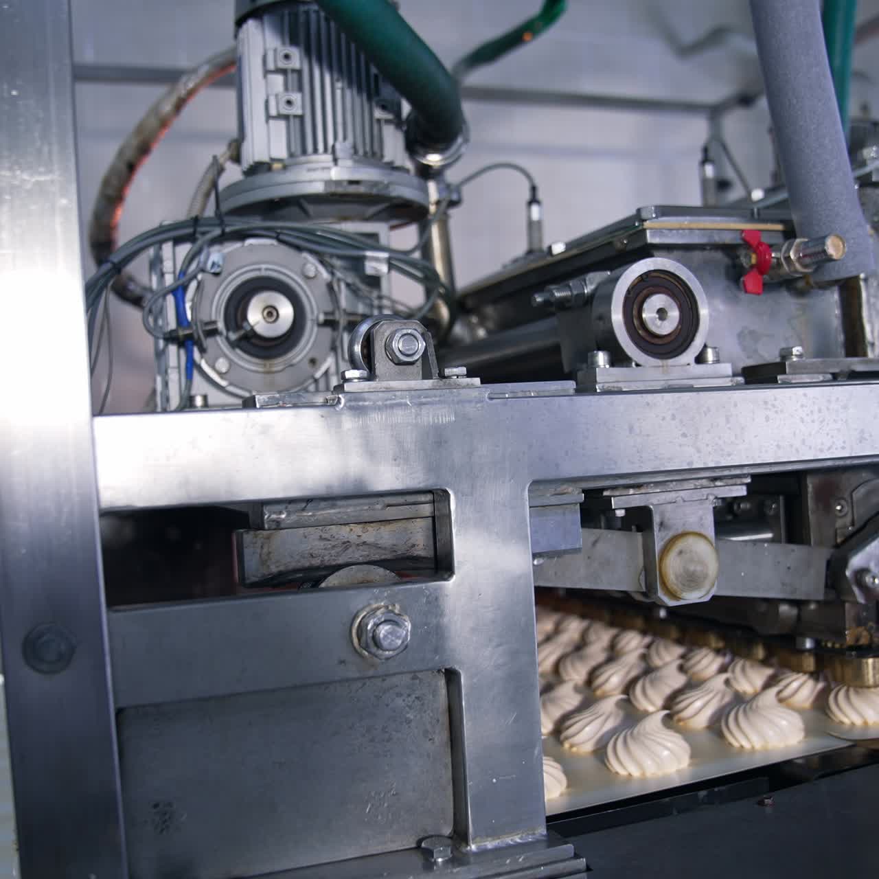 Complicated mechanism moving to produce marshmallow desserts. Automated line at manufacturing sweets
