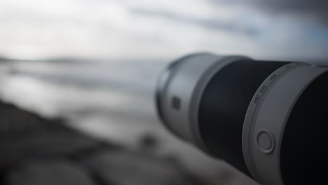 close up of a telephoto lens pointing at the ocean