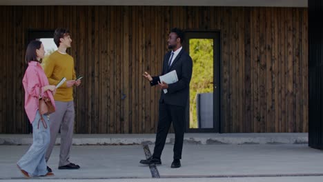 real estate agent showing modern house to couple