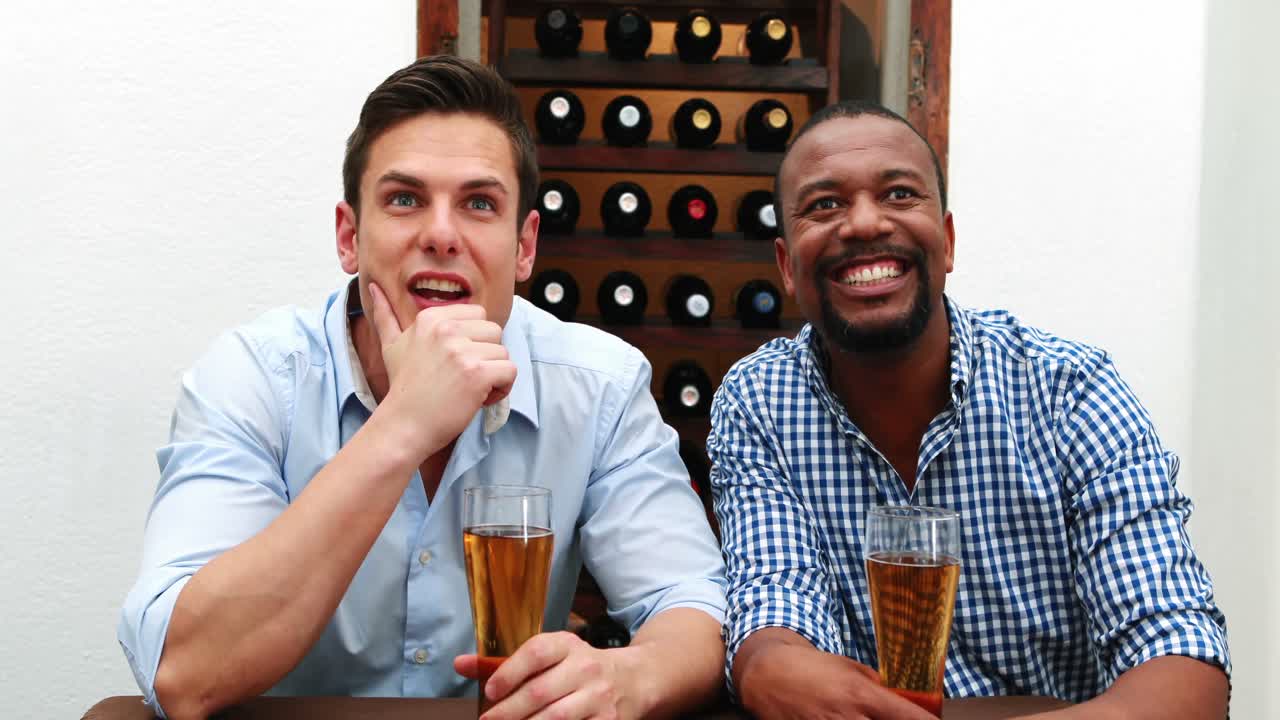 남자 친구 들 이 맥주 4k 를 마시면서 축구 경기 를 보고 있다