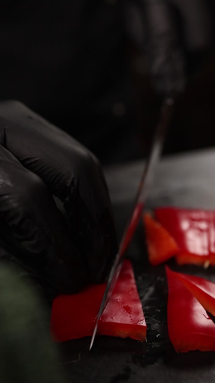 el chef cortando pimientos rojos