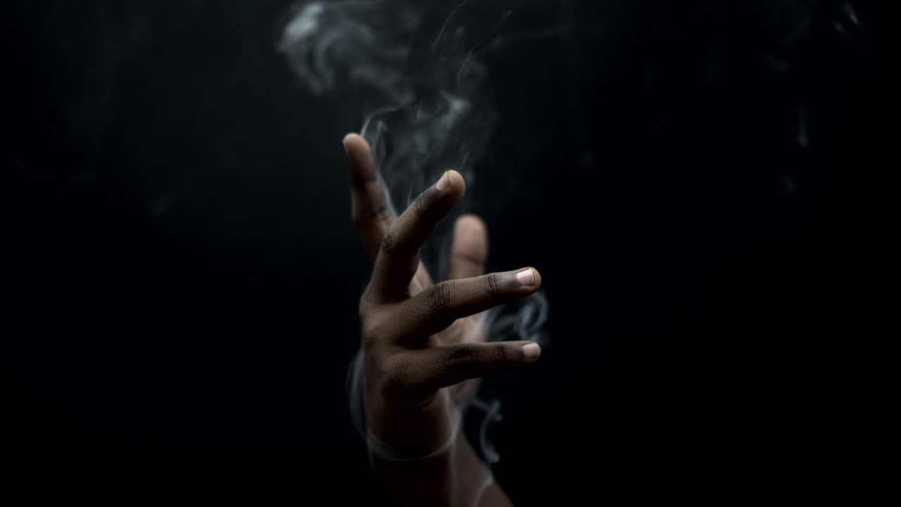 comunicaciones de humo en la mano en la vista de primer plano de fondo negro