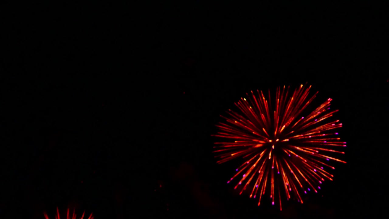 Fuochi d'artificio colorati che esplodono nel cielo notturno, creando un'atmosfera festosa spettacolare con scintille luminose, scie incandescenti e giochi di luce drammatici
