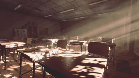 view to classroom with tables and small blackboard and grungy walls