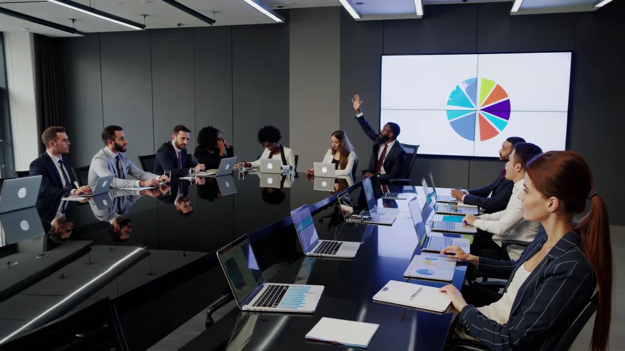 A high-angle video shot of a modern conference room with diverse ...