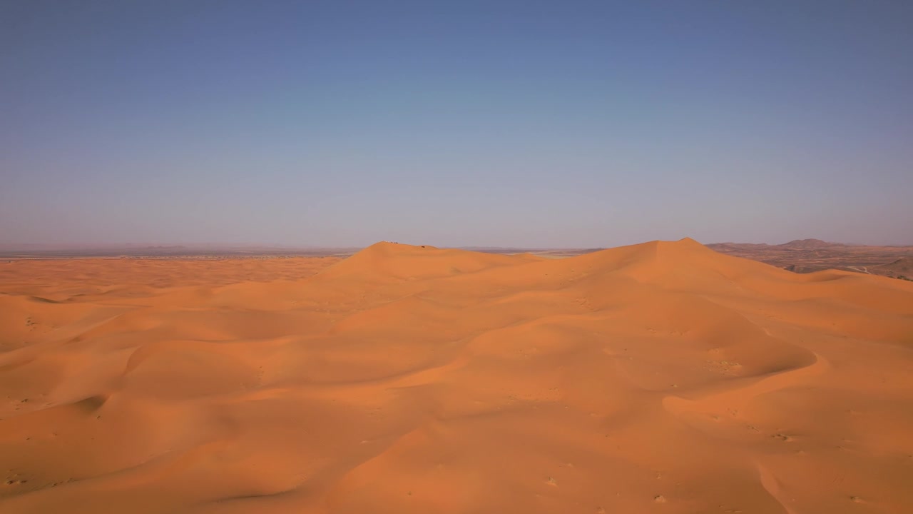 L'Erg Chebbi si estende attraverso Merzouga, provincia di Errachidia, Drâa-Tafilalet, Marocco, rivelando un immenso mare di sabbia modellato da processi eolici e dalla migrazione di dune spinta dal vento, ascesa in sorvolo in avanti
