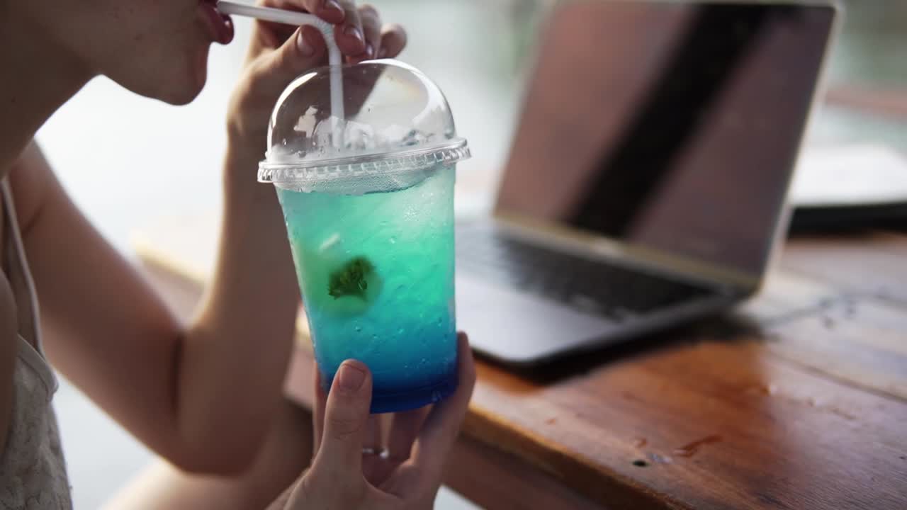 휴가 중  ⁇ 으로 상쾌한 얼음 음료를 마시는 가까운 여성