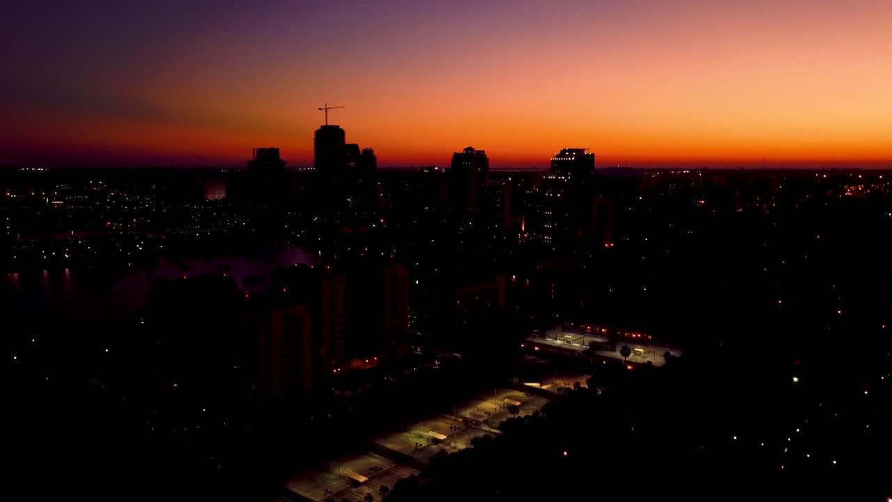 Vídeo aéreo 4K de pôr do sol laranja sobre condomínios no centro de St. Petersburg, Flórida