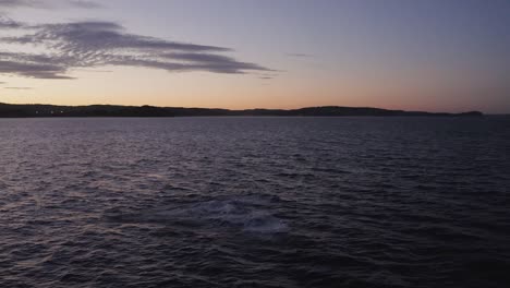 aerial drone footage of humpback whale breaching off sydney northern beaches coastline during golden hour sunset, playing around during migration