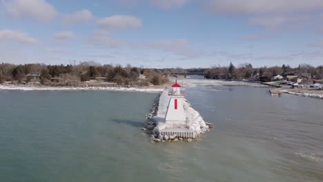 Winter-view-of-the-Southampton-lighthouse-with-a-frosted-pier,-aerial-perspective,-gentle-waves