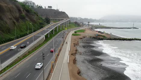 cars travelling at scenic beach roadway along playa la estrella in lima, peru