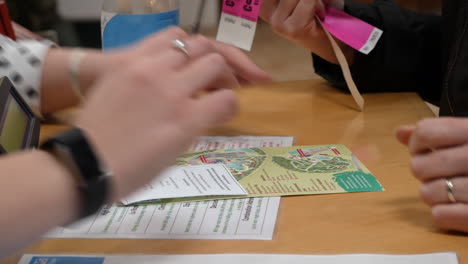 a woman is given a theme park map at a reception desk and theme park passes