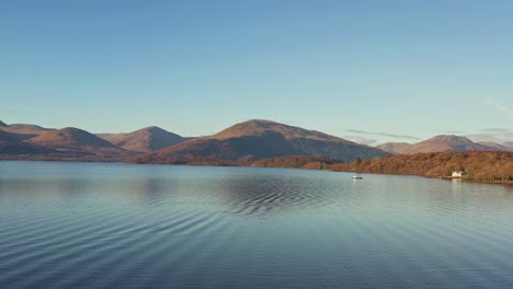 Lago-Lomond-Y-El-Parque-Nacional-Trossachs-Con-Un-Drone-Volando-Bajo-Elevándose-Sobre-El-Lago-En-Escocia