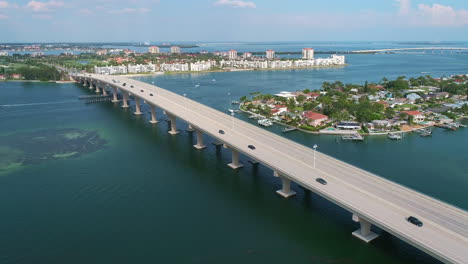 Vuelo-De-Drones-Siguiendo-El-Puente-Corey-Causeway-Acercándose-A-La-Playa-En-El-Condado-De-Pinellas