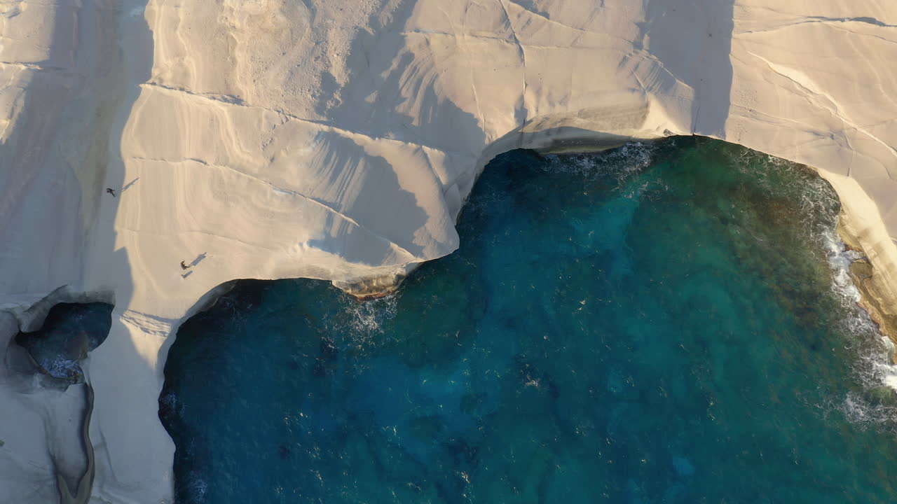desde el aire: vista de arriba hacia abajo de la playa de sarakiniko en la isla de milos, cícladas, grecia durante el amanecer
