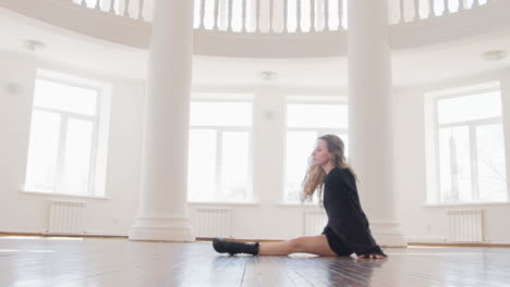 focused blonde woman in black long sleeve loose pullover and boots performing a contemporary dance in the studio 2