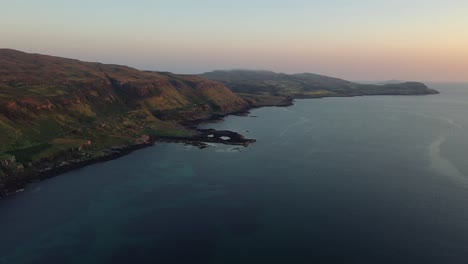 Drone-Lento-A-Través-De-La-Playa-De-Calgary-Revelando-Acantilados-Al-Atardecer