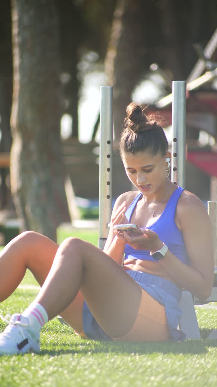 Woman using cell phone after exercise outdoors