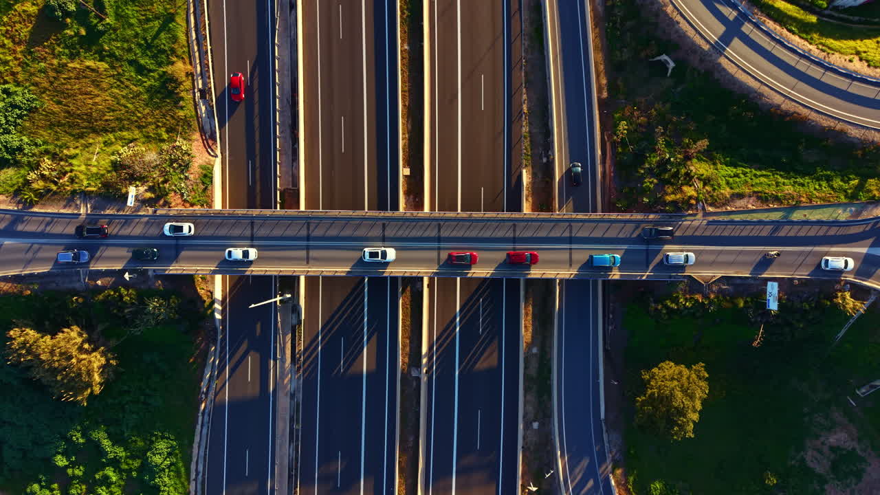 Le auto viaggiano sulle autostrade in un'area urbana di giorno con cieli sereni sopra e spazi verdi nelle vicinanze
