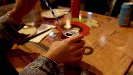 insertando paja a mano en una lata de coca-cola