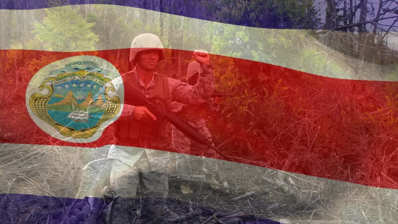 Soldados patrulhando a vegetação rasteira em treinamento de defesa enquanto a bandeira tremula, revelando uma clareira na floresta.