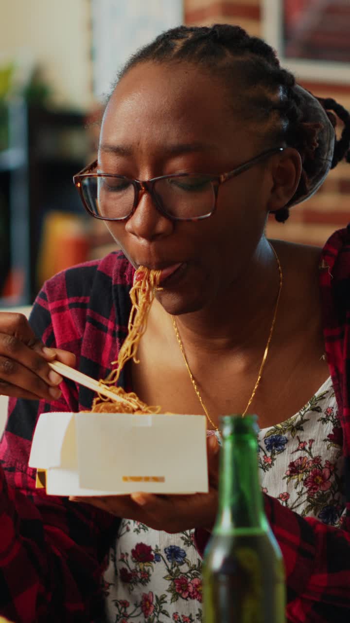 Video verticale: personaggio femminile usa le bacchette per mangiare cibo asiatico