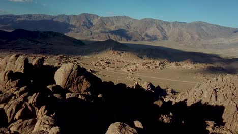 Cinematic-Aerial-View-on-Rugged-Cliffs,-Valley-Under-Alabama-Hills-and-Clouds-Shadows-on-Ground,-California-USA