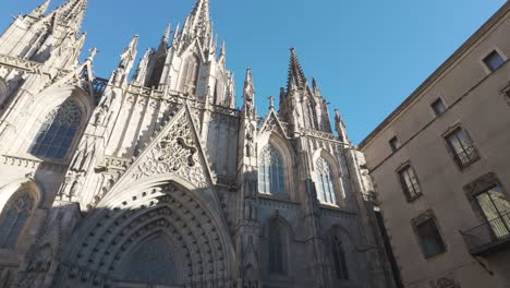 a stunning view of the intricate details of the barcelona cathedral under a clear blue sky. pan left shot