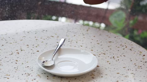 hand reaching for coffee cup on table