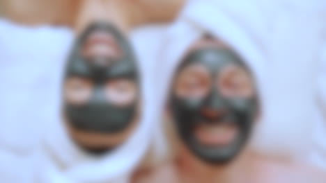 Blurred-shot-of-close-up-couple-with-a-detox-clay-mask-on-at-the-spa,-well-being-and-healthy-lifestyle-concept