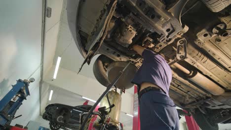 auto mechanic is changing motor oil into a engine at car station. automated oil change with modern equipment