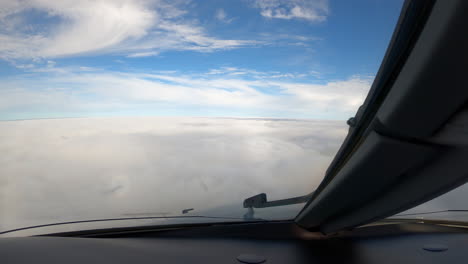 pilot view from cockpit, aircraft descending through overcast clouds