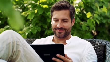Man Relaxing Outdoors with a Tablet