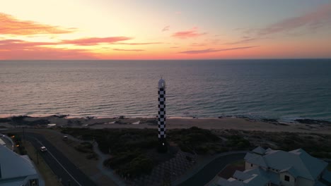 Un-Dron-Disparó-Alrededor-Del-Faro-De-Bunbury-Al-Atardecer-Con-Nubes-Coloridas-En-El-Fondo,-Hora-Dorada,-Australia-Occidental