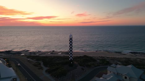 drone disparado alrededor del faro de bunbury al atardecer con nubes coloridas en el fondo, hora de oro, australia occidental