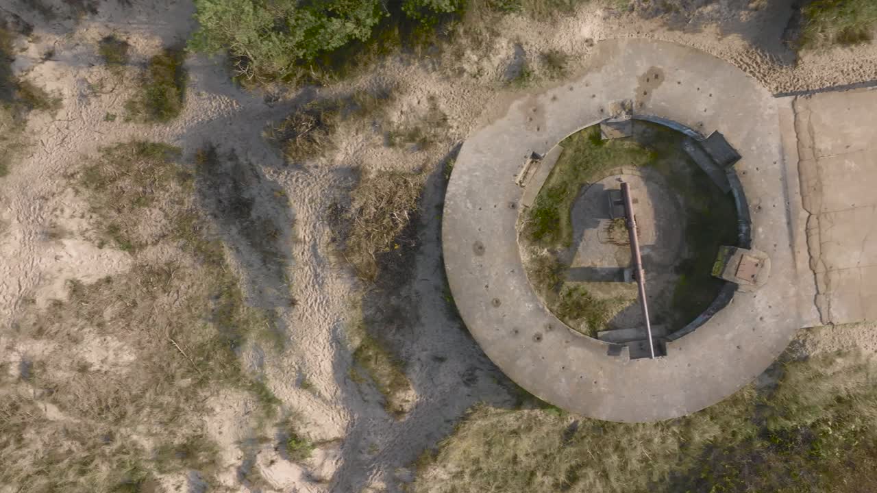 вид с воздуха на оборонительную башню времен второй мировой войны с сохранившимся орудием на побережье балтийского моря